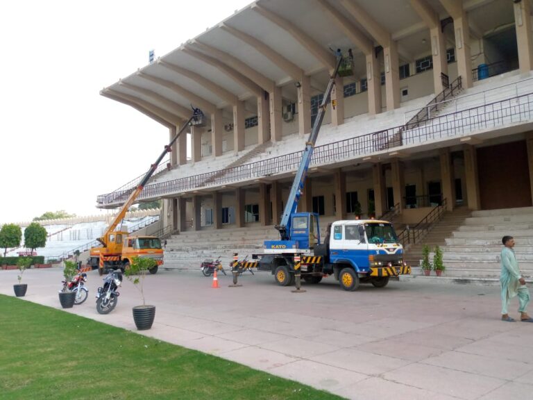 Two mobile man lifting cranes operating at a stadium building in Lahore, provided by National Crane Service.